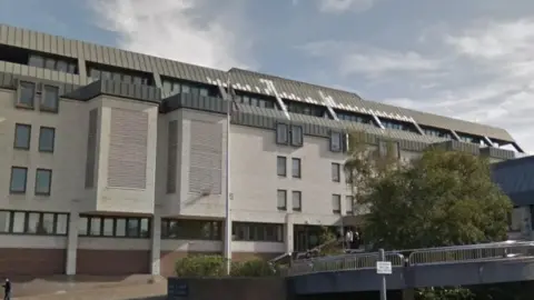 Google The outside of Maidstone Crown Court, a grey and white modernist building.