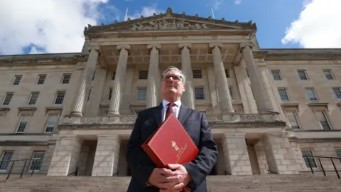 PA Sir Keir Starmer outside Parliament Buildings in Belfast holding a red binder