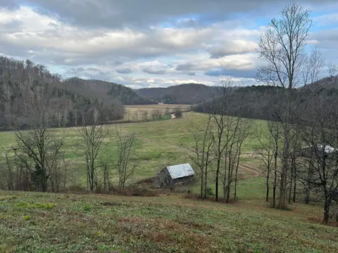 BBC/Ellie House Sebuah gudang terletak di antara rumpun pepohonan dan perbukitan