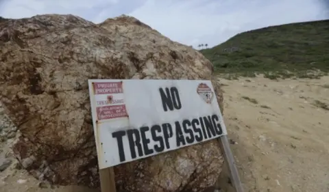 a sign on Epstein's property warning people there is no trespassing in the area.