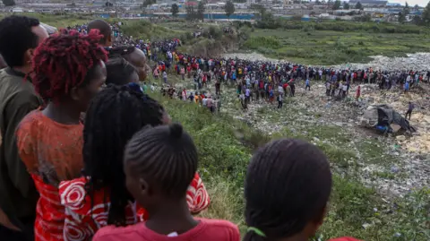 EPA Locals look on as police investigate the dump site