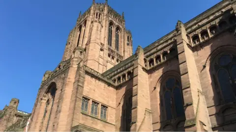 An outside view of Liverpool Cathedral with clear blue skies above it