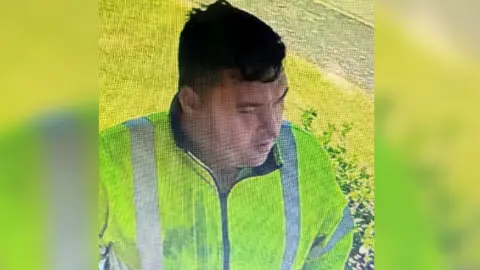 Lincolnshire Police A man with short dark hair, wearing a yellow high visibility jacket.