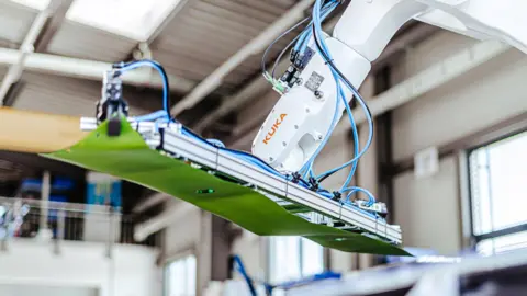 Robotextile A robotic arm moves a piece of green cloth.
