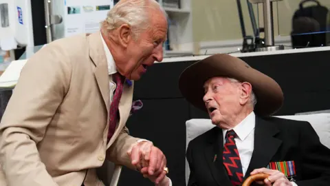 PA Media The king in conversation with James Fenton, who is wearing his military hat.