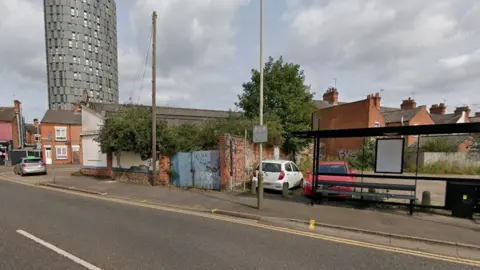 Google A bus stop in front of a car park and a garage