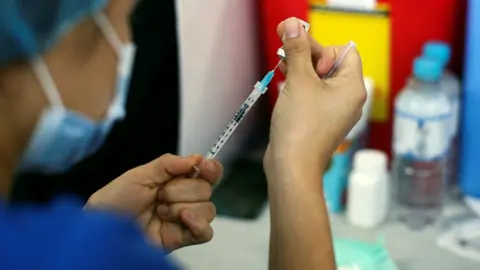 Reuters A healthcare worker prepares a dose of Pfizer-BioNTech coronavirus disease (COVID-19) vaccine