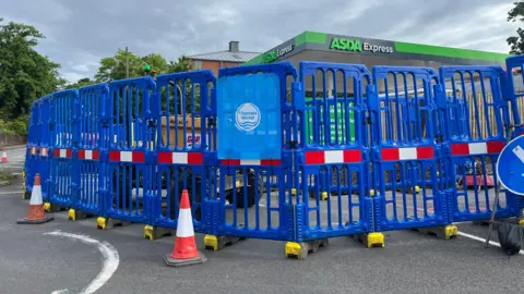 BBC/Julia Gregory Thames Water works to replace a pipe outside the petrol station where the leak occurred