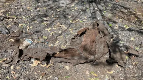 A burnt pile of clothing surrounded by scorched earth