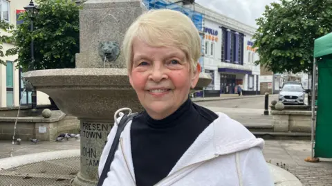 Ann Petters standing in front of a fountain in the market square