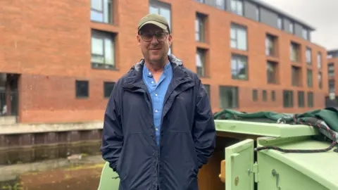 Ian Furmidge standing on the deck of his narrowboat, along the Nottingham and Beeston Canal
