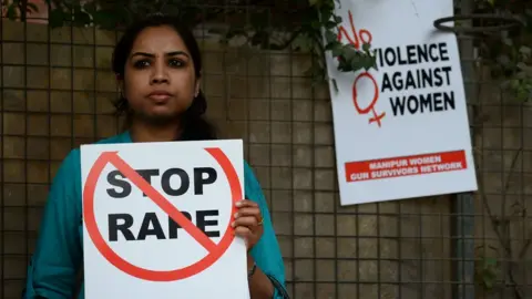 AFP A woman holds a sign saying Stop Rape during a protest in India