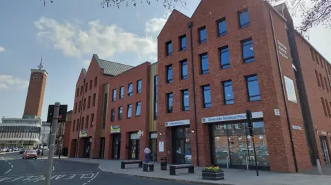 Shropshire Council Three and four storey red brick buildings alongside a town centre road