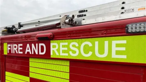 A close up of a red fire engine with 'fire and rescue' in white writing 