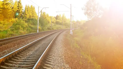 Getty Images A hazy image of railway tracks in bright sunlight as the sun sets. 