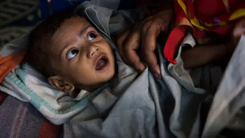 Getty Images A malnourished child waits for treatment at a clinic in Kolkata's Fakir Bagan slum. The clinic is run by the Calcutta Kids charity. Founded in 2004, Calcutta Kids is a non-profit public health organization committed to the health and empowerment of needy women and young children in Kolkata's Fakir Bagan area.