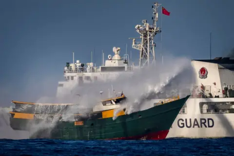 Getty Images A Chinese Coast Guard ship fires a water cannon at Unaizah May 4, a Philippine Navy chartered vessel, conducting a routine resupply mission to troops stationed at Second Thomas Shoal, on March 05, 2024 in the South China Sea