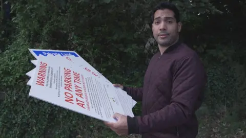 BBC Omar Hamdi from BBC Wales' X-Ray with some of the parking signs