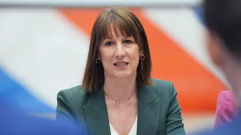 Getty Images Headshot of Chancellor Rachel Reeves in a green suit with part of the Union Jack behind her