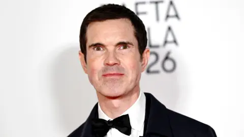 Getty Images Jimmy Carr in a black bow tie and suit