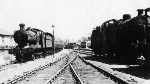 North Sedgemoor Local History Group A black and white photo of two steam trains.