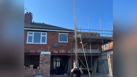 Man balances a huge pole on his chin.