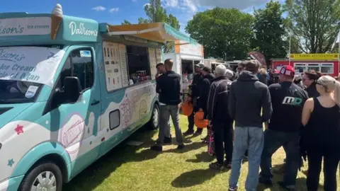 DAVISON'S A Davison's Ice Cream van, which has its side hatch open, with a queue of people waiting to be served.