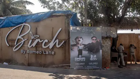 Anadolu via Getty Images Police officers stand outside the 'Birch by Romeo Lane' nightclub in Goa, where 25 people were killed and six injured on December 7.