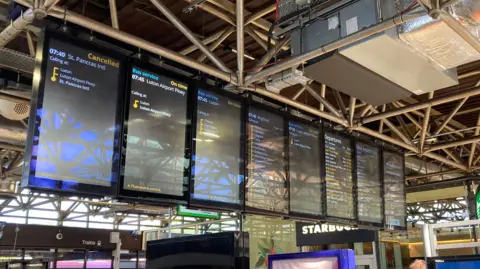Alex Pope/BBC Electronic boards amusement   cancelled services astatine  Bedford Railway Station.