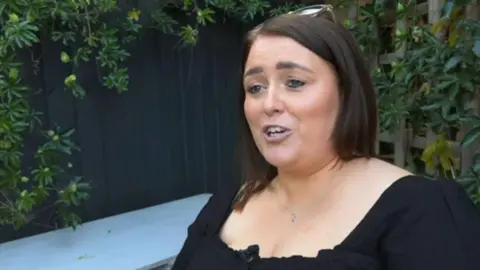 BBC Sammi wearing a black top in her garden