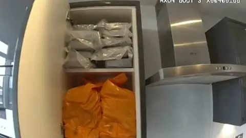National Crime Agency Bags stored in a cupboard in a kitchen.