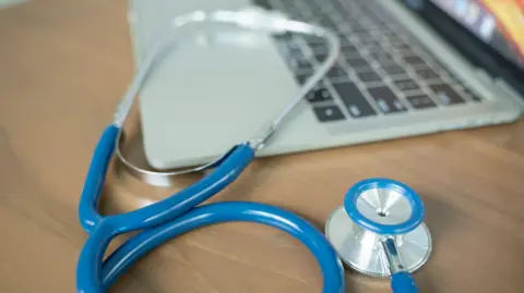 Doctor's desk with laptop and stethoscope