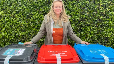 Cllr Lauren Townsend Councillor Lauren Townsend standing by three wheelie bins in Milton Keynes