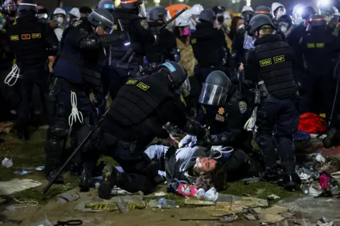 Mike Blake/Reuters Law enforcement officers detain a protester at the University of California in Los Angeles, during a pro-Palestinian protest, USA, May 2 2024.