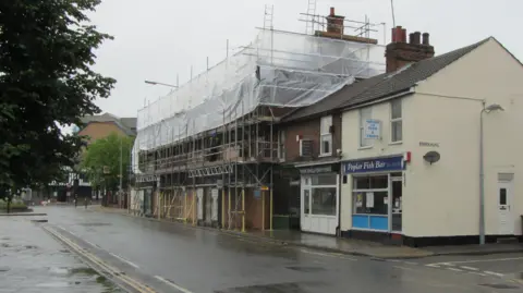 Two buildings on Woodbridge road in Ipswich, the ICA club is surrounded by scaffolding.