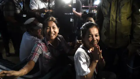 AFP/Getty Family members celebrating and looking emotional, as tv cameras film their reaction.