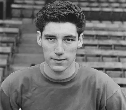 Getty Images A youthful head and shoulders black and white portrait shot of Phil Parkes with short hair and a dark top, with empty eats in the background
