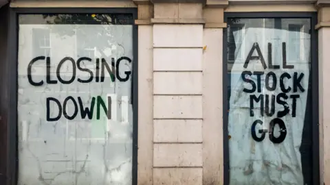 Getty Images Shop windows with signs in saying Closing Down and All Stock Must Go in capital letters