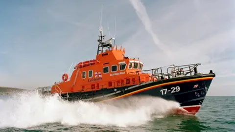 Falmouth’s Severn class all-weather lifeboat Richard Cox Scott on exercise in Falmouth Bay. The lifeboat is orange and dark blue. There is writing at the on the side towards front which states '17-29'. 