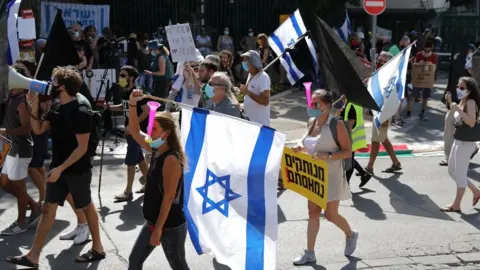 EPA People protest in Jerusalem before an Israeli parliamentary vote on a law that allows ministers to curb mass protests (29 September 2020)