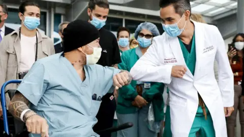 Getty Images A recovering Covid patient in LA receives an elbow bump from a doctor