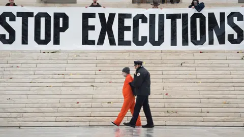 Getty Images Protesters erecting a large banner reading "stop executions" outside the US Supreme Court in 2017