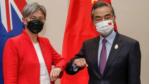 Getty Images Penny Wong and Wang Yi bump elbows