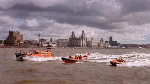 Rnli lifeboats sail past Liverpool Pier Head