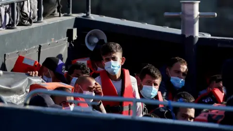 PA Media A group of people thought to be migrants are brought in to Dover from a Border Force vessel following a small boat incident in the Channel