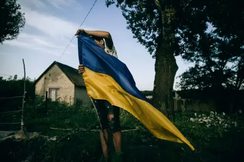 Julia Kochetova from the series, War is Personal A man with a Ukrainian flag