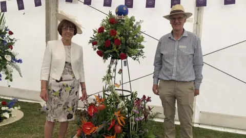 Lucy Lightfoot/BBC Martyn Davies and Gloria Goodly with the winning floral display in the Garden Village