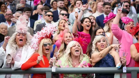 EPA-EFE/REX/Shutterstock Crowds cheering on horse race at Aintree Ladies day 2024