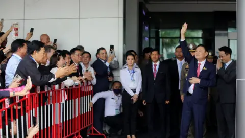 Getty Images Former Thai prime minister Thaksin Shinawatra greets supporters as he arrives at Don Mueang International Airport on August 22, 2023 in Bangkok, Thailand.