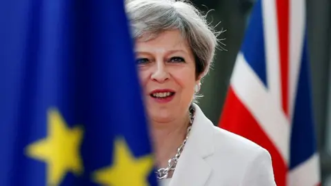 Reuters Theresa May next to EU ad UK flag